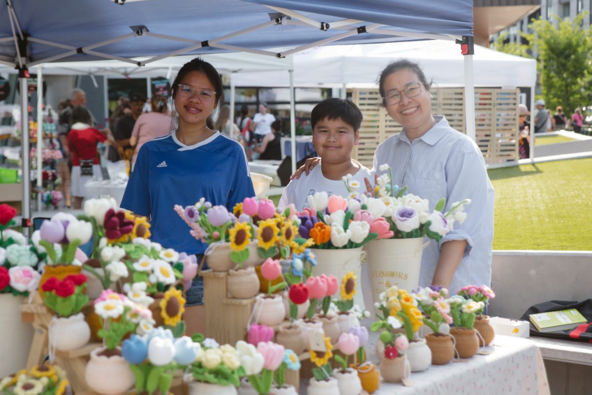 Vendor family behind a table of handmade crochet flowers