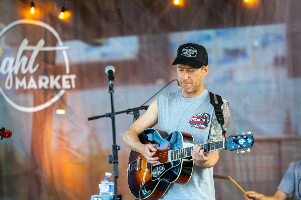 Musician playing guitar on the night market stage