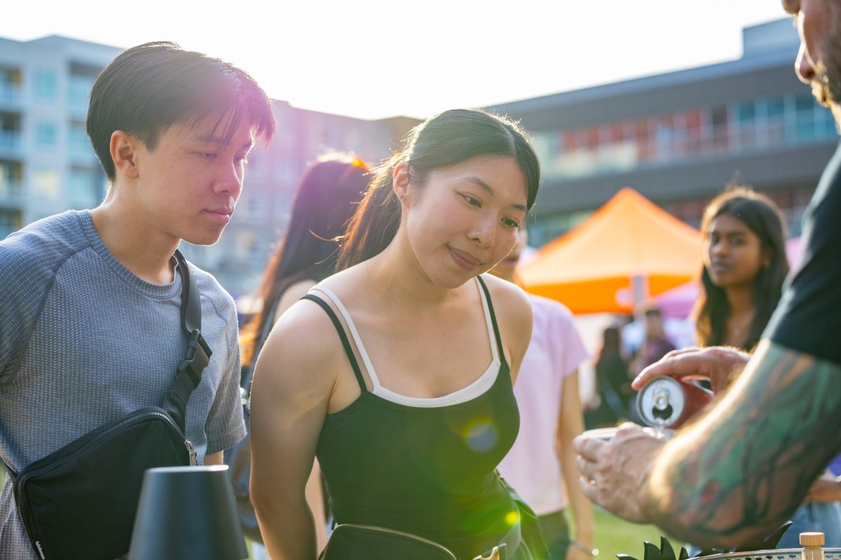 Two shoppers being served at a vendor table at golden hour