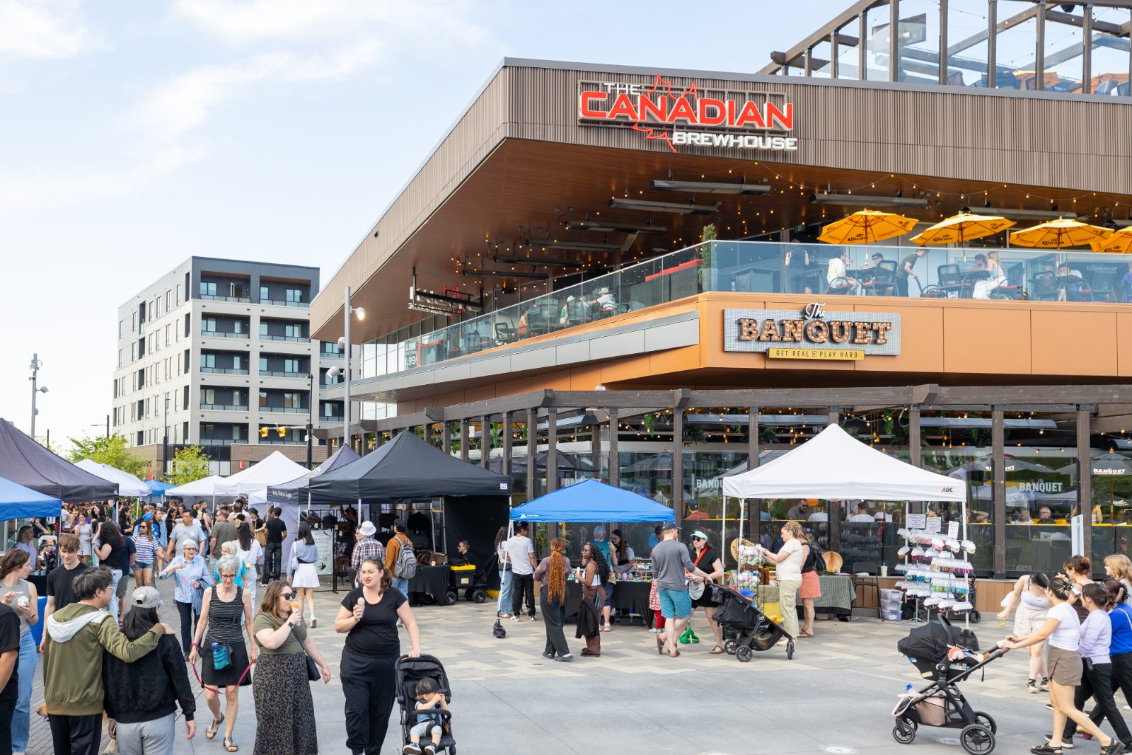 Market tents filling the plaza on a summer evening