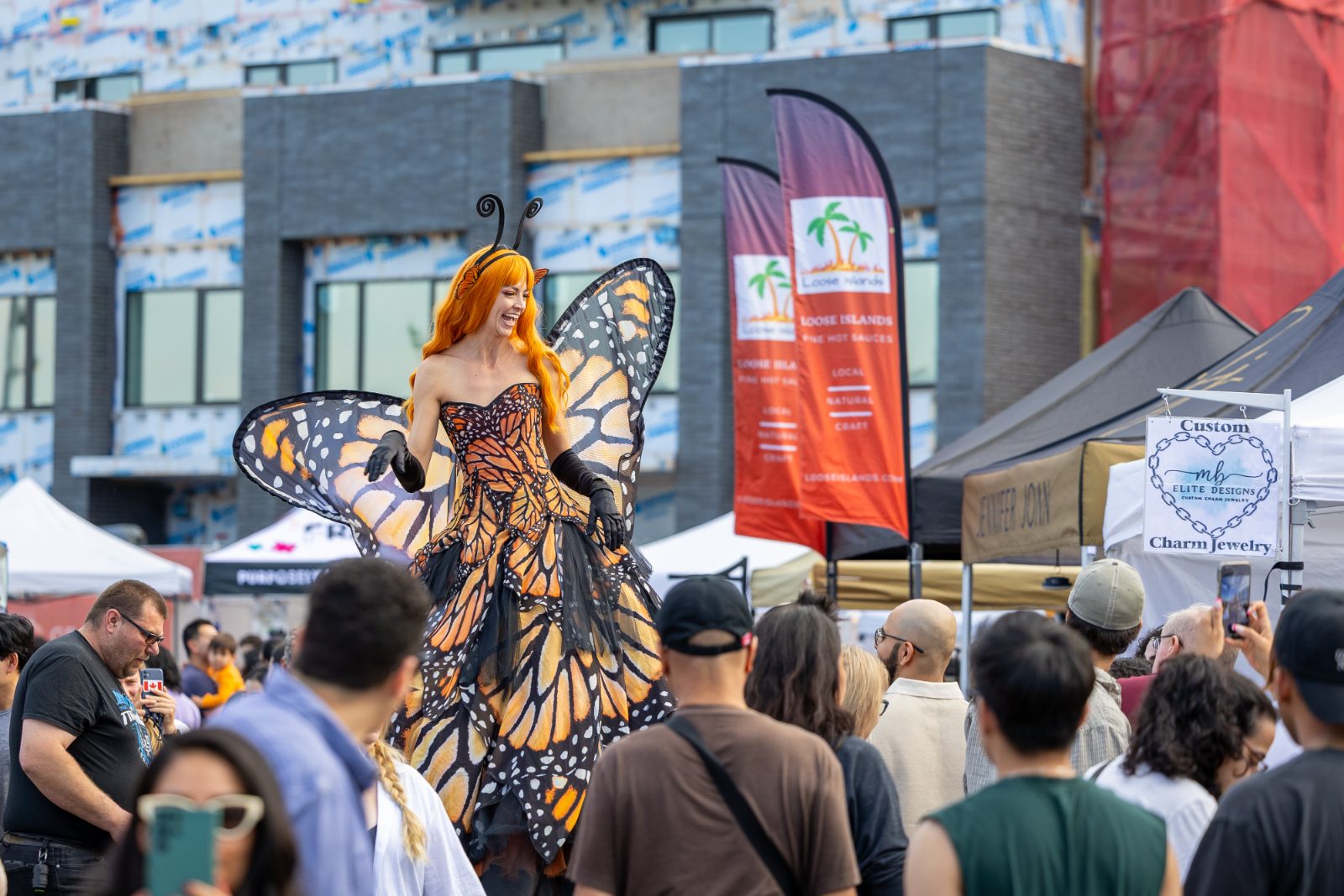 Stilt-walking butterfly performer greeting the crowd